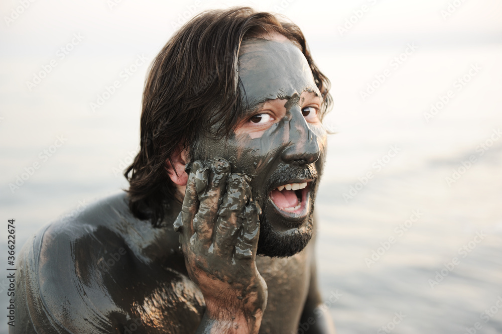 Naklejka premium Man in a bathing of natural mineral mud from the dead sea
