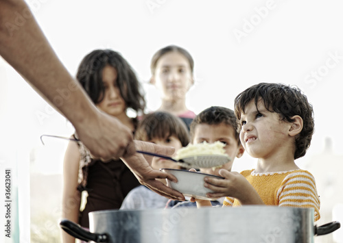 Canvas Print Hungry children in refugee camp, humanitarian food
