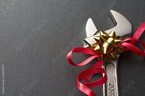 Spanner with ribbon on the grey background photo