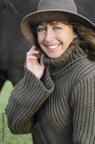 A happy smiling mature woman wearing hat.