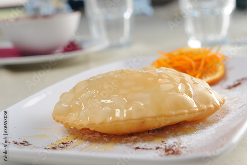 fried sebadas on a restaurant table photo