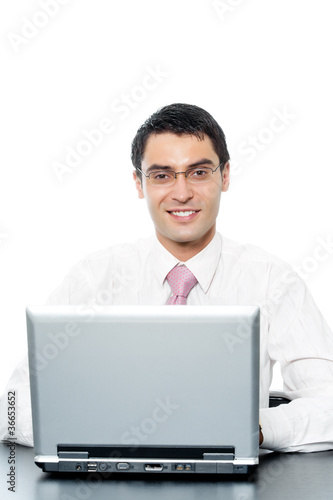 Young businessman in glasses working with laptop