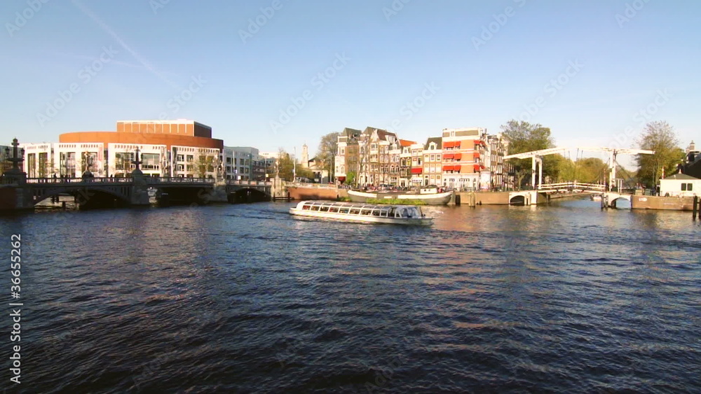 Amsterdam touristic boats passin in a canal Amsterdam touristic boats passin in a canal