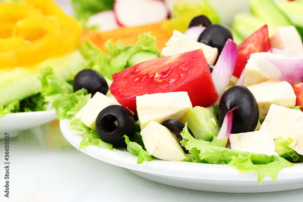 Tasty greek salad on plate isolated on white Tasty greek salad on plate isolated on white