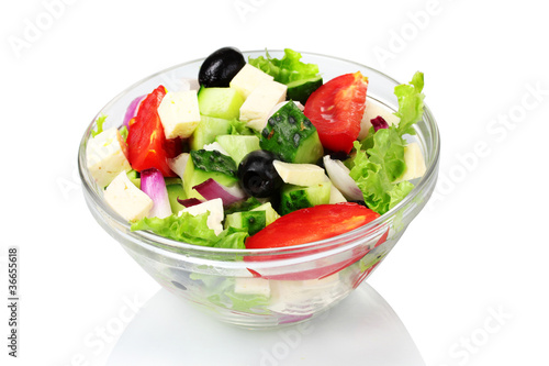 Tasty greek salad in transparent bowl isolated on white