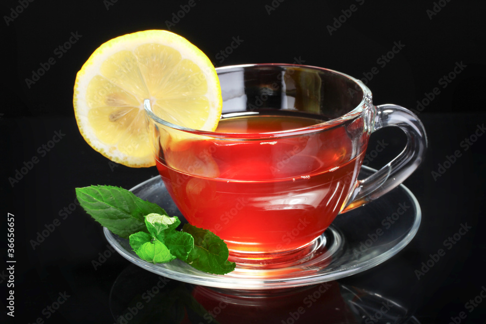 tea with lemon and mint on black background