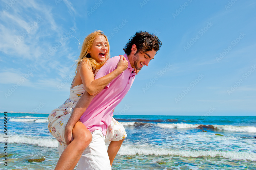 An attractive couple fooling around on the beach An attractive couple fooling around on the beach