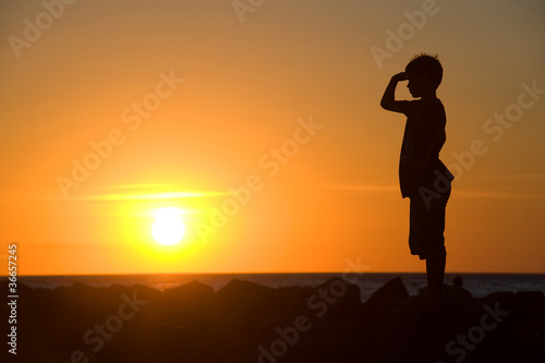Young boy enjoying sunset photo