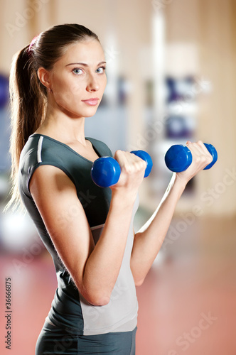 Beautiful sport woman doing exercise with dumbbell