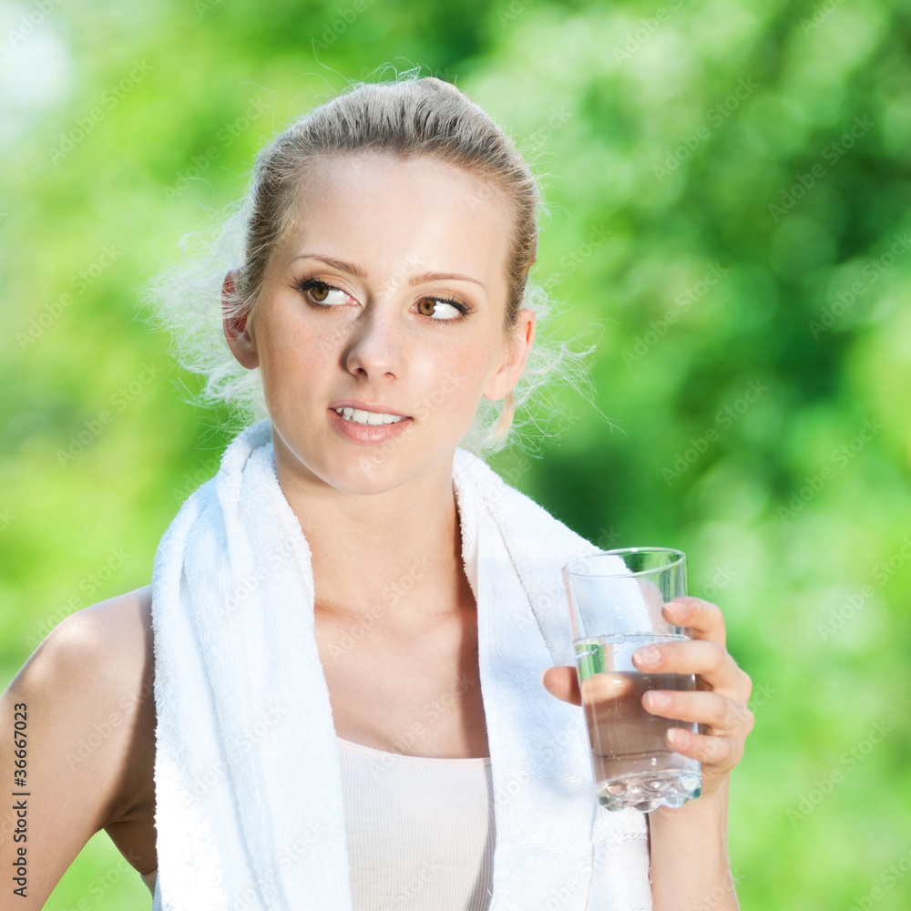 Woman drinking water after exercise Woman drinking water after exercise