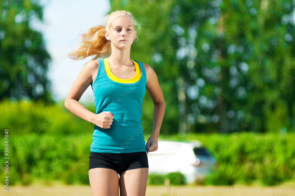 Young woman running in green park Young woman running in green park