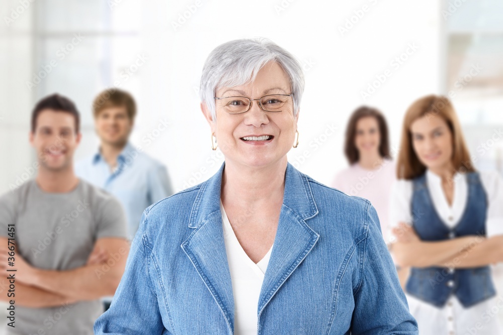Happy senior teacher with students in background Happy senior teacher with students in background