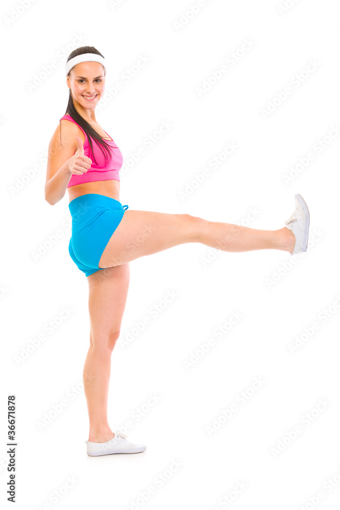 Full length portrait of smiling fitness girl with raised leg Full length portrait of smiling fitness girl with raised leg
