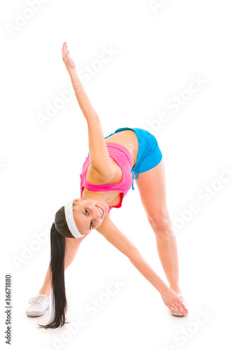 Full length portrait of smiling healthy girl making exercise