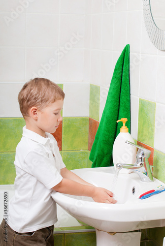 little boy washes in a bathroom