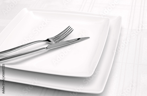 White plates on white tablecloth
