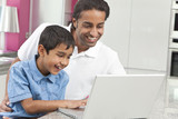 Asian Indian Father & Son Using Laptop Computer at Home