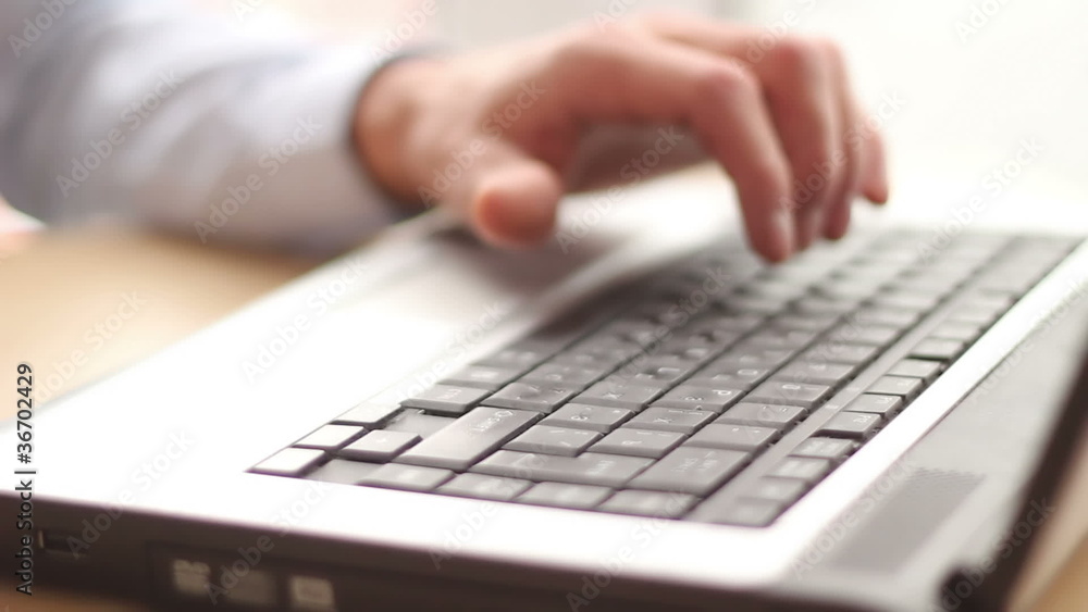 Man typing text using his laptop at office Man typing text using his laptop at office