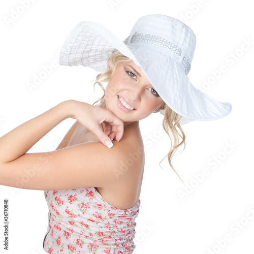 Young blonde fashion woman in a big hat posing in studio