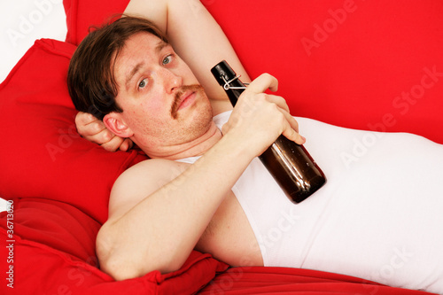 Mann mit Bierflasche auf Couch photo