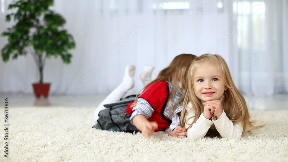 Sisters smiling while lying on the carpet. DOLLY HD
