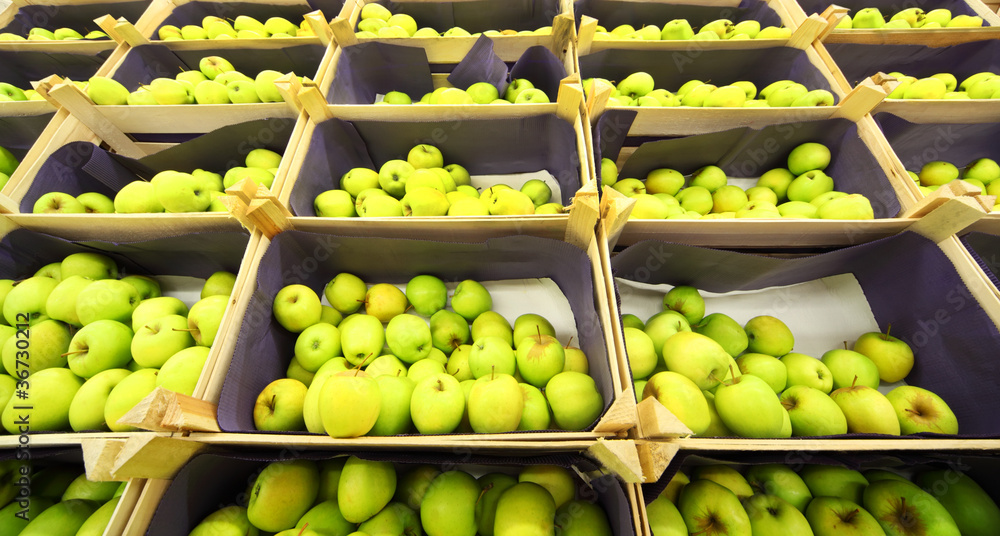 Beautiful juicy green apples in boxes in shop