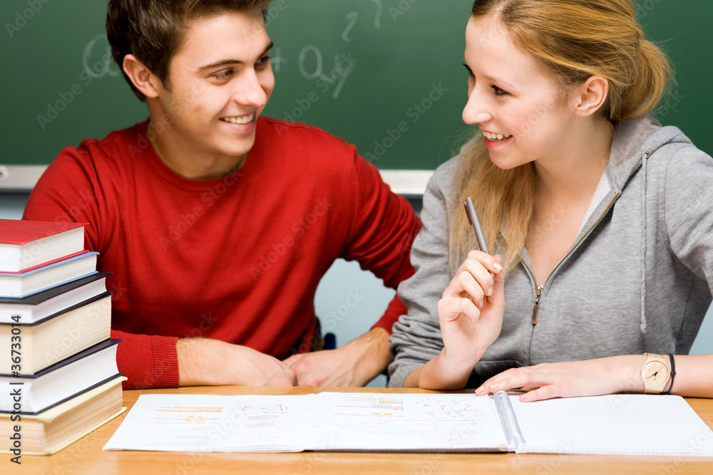 Couple working together on school work in classroom Couple working together on school work in classroom