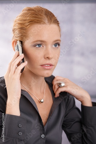 Young businesswoman concentrating on call