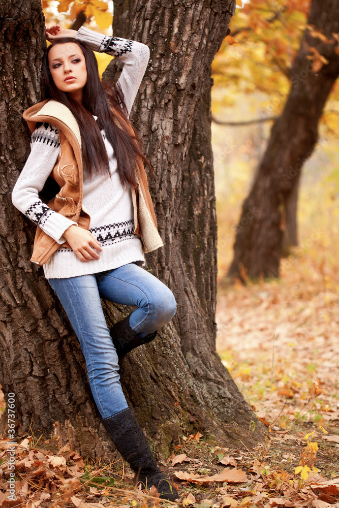 woman posing near tree in autmn park