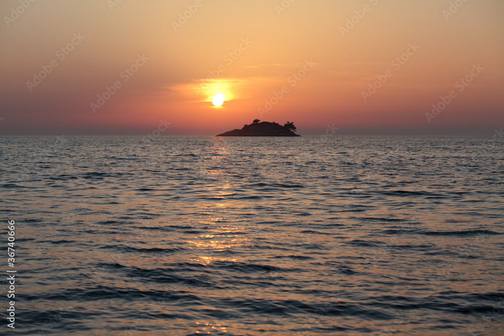 sunset behind an island