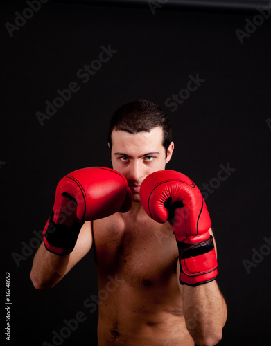 Man with boxing gloves on black background