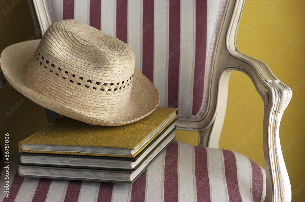 Sombrero con libros en una silla