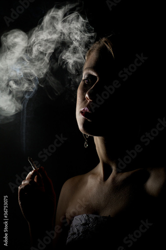beautiful woman with a cigarette in the dark