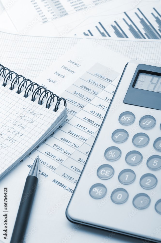The calculator and the financial report blue toned The calculator and the financial report blue toned