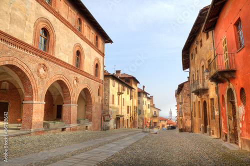 Fototapeta Naklejka Na Ścianę i Meble -  Paved street among historic houses in Saluzzo, Italy.