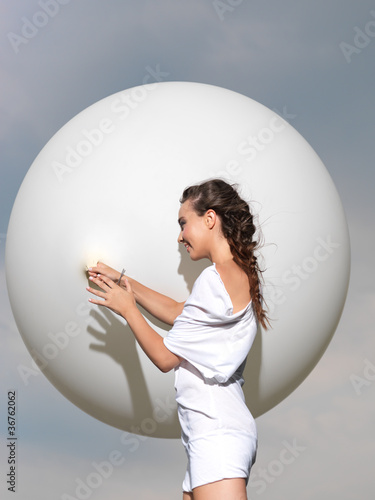 happy young woman standing with white balloon