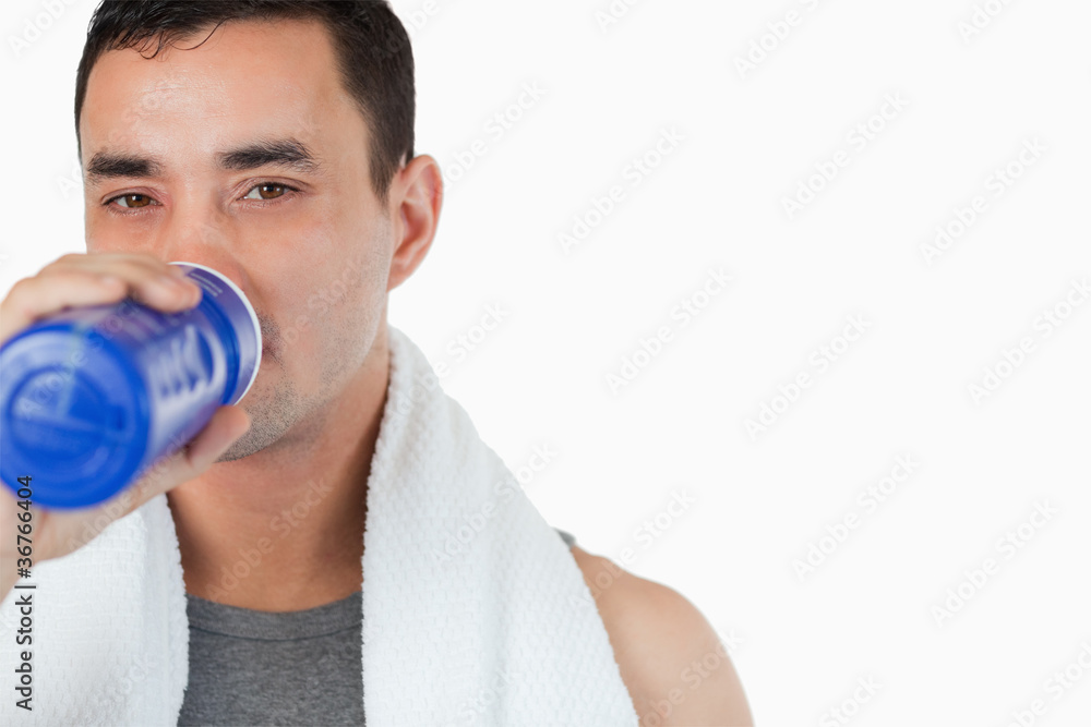 Young male taking a sip of water after training Young male taking a sip of water after training