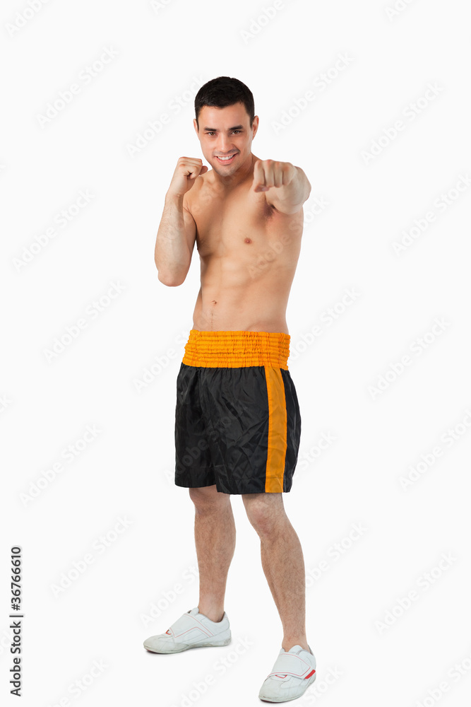 Young boxer with bare fists striking straight Young boxer with bare fists striking straight