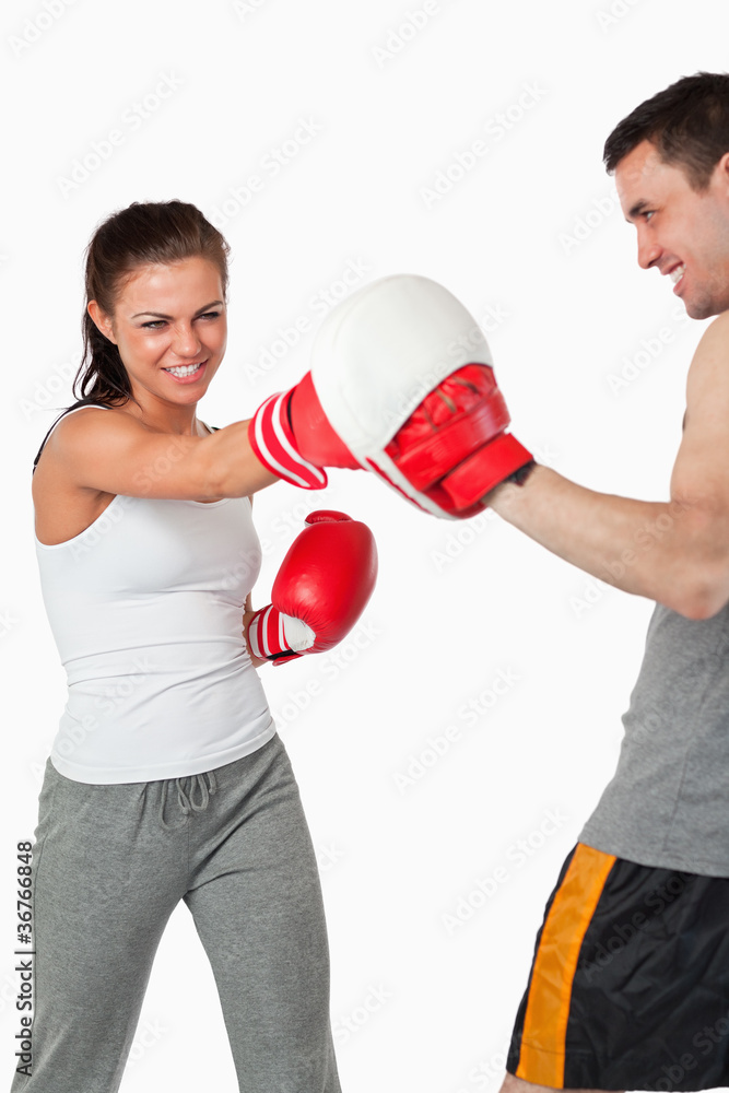 Aggressive female boxer striking her target Aggressive female boxer striking her target