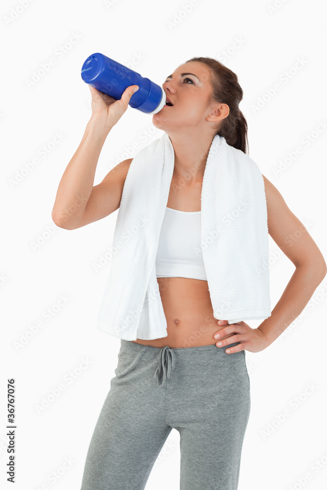 Young female taking a sip out of her bottle after workout Young female taking a sip out of her bottle after workout