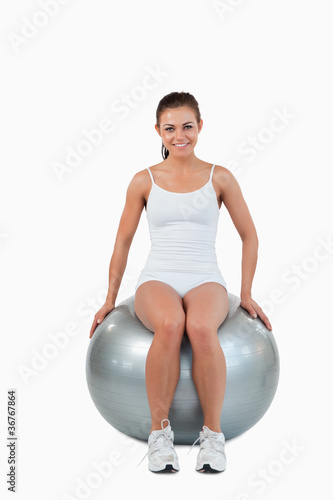 Portrait of a happy woman working out with a ball