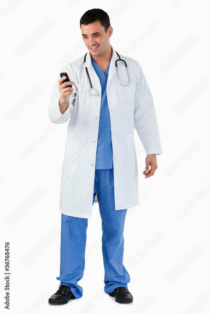 Portrait of a doctor dialing on his mobile phone Portrait of a doctor dialing on his mobile phone