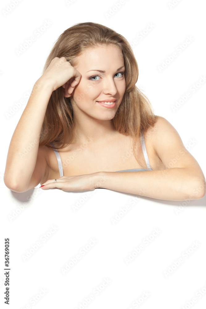 Woman standing behind and leaning on blank billboard Woman standing behind and leaning on blank billboard