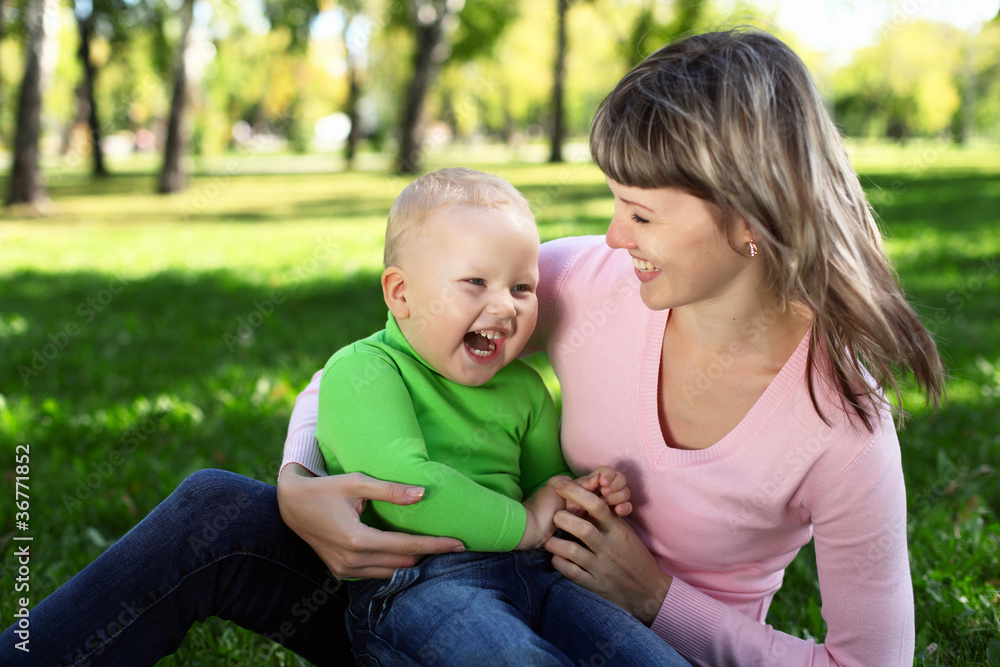 Young mother with her son in summer park Young mother with her son in summer park
