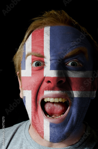 Face of crazy angry man painted in colors of iceland flag photo