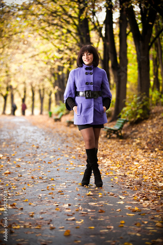 beautiful girl in coat posing standing in autumn park