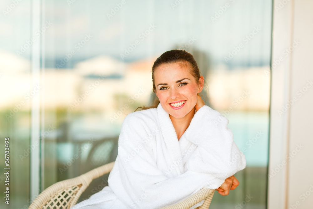 Portrait of lovely smiling woman in bathrobe sitting at terrace Portrait of lovely smiling woman in bathrobe sitting at terrace