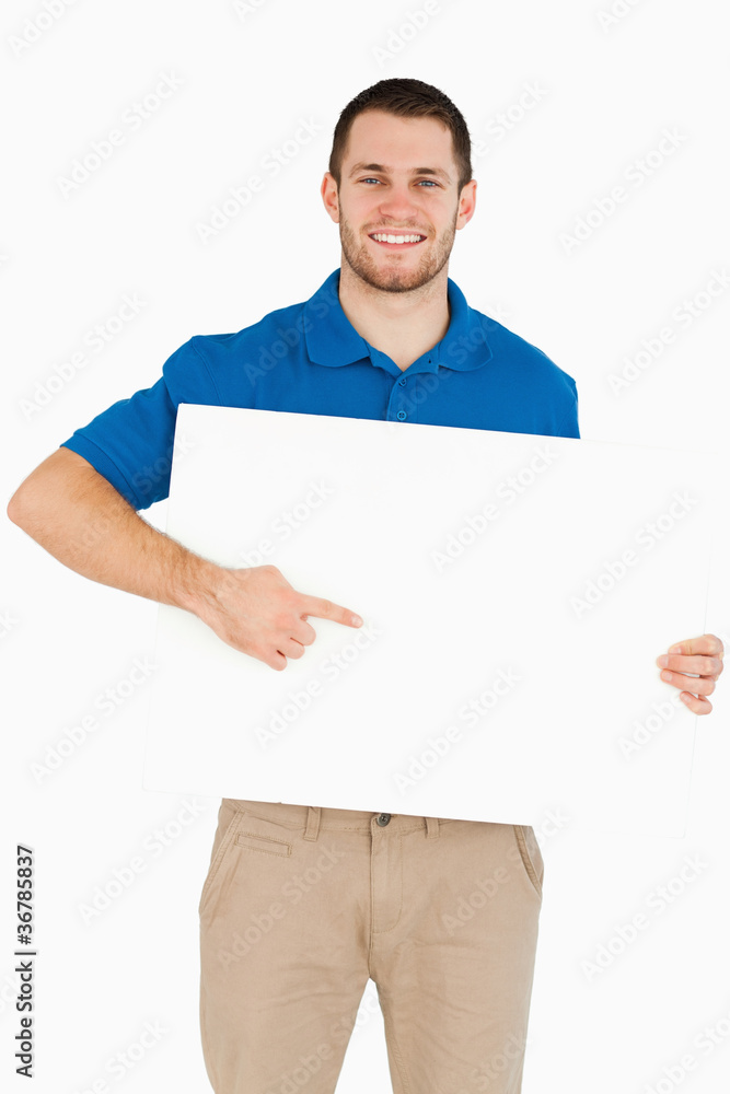 Smiling young salesman pointing at banner in his hands Smiling young salesman pointing at banner in his hands