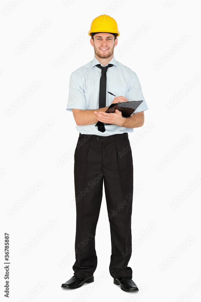 Smiling young foreman taking notes on his clipboard Smiling young foreman taking notes on his clipboard