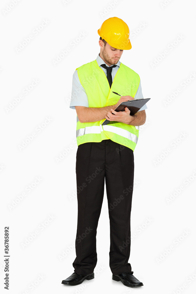 Young foreman in safety jacket taking notes on clipboard Young foreman in safety jacket taking notes on clipboard